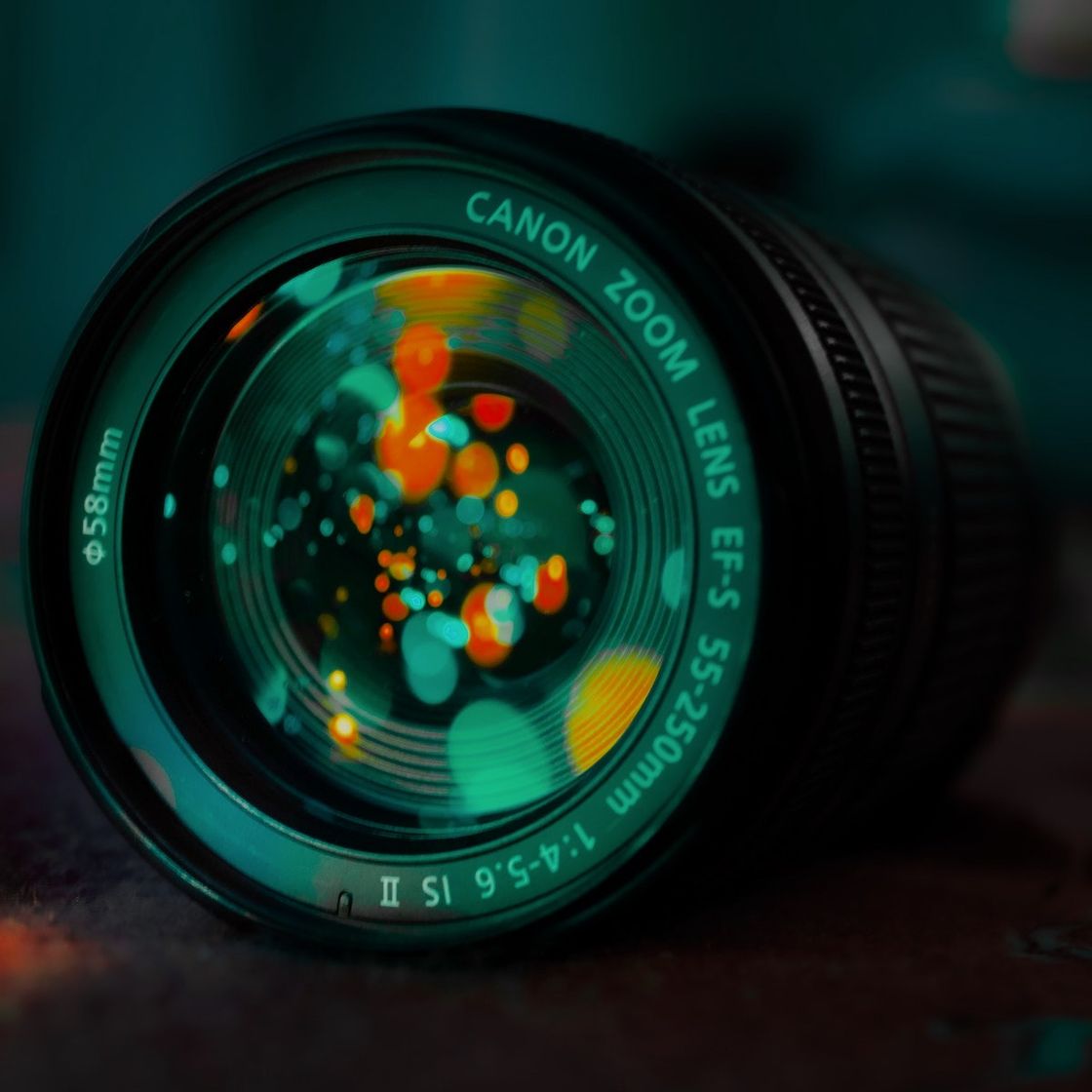 Close up of a camera lens with a glowing orange bokeh