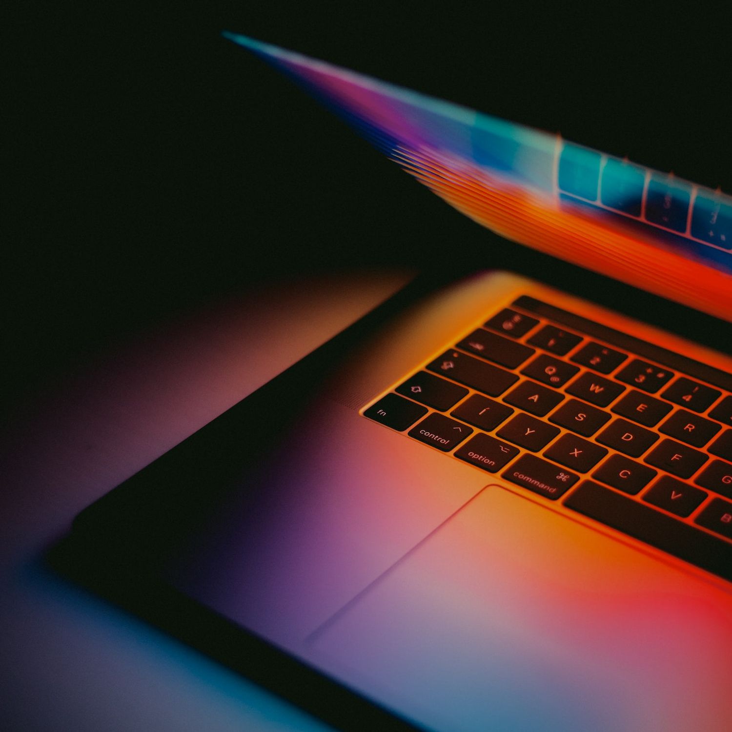 A macbook laptop glows neon orange
