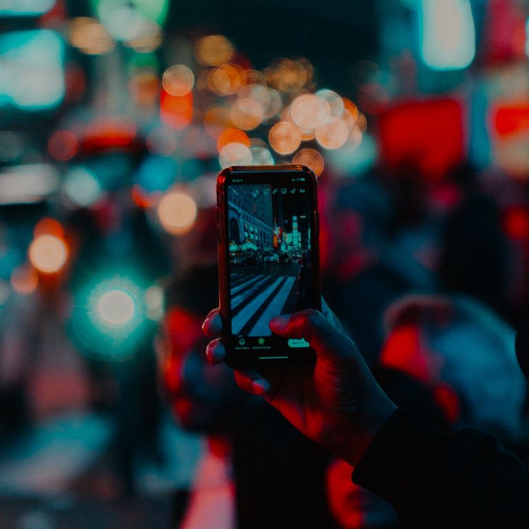 A glowing mobile phone screen, infront of soft focus bokeh background