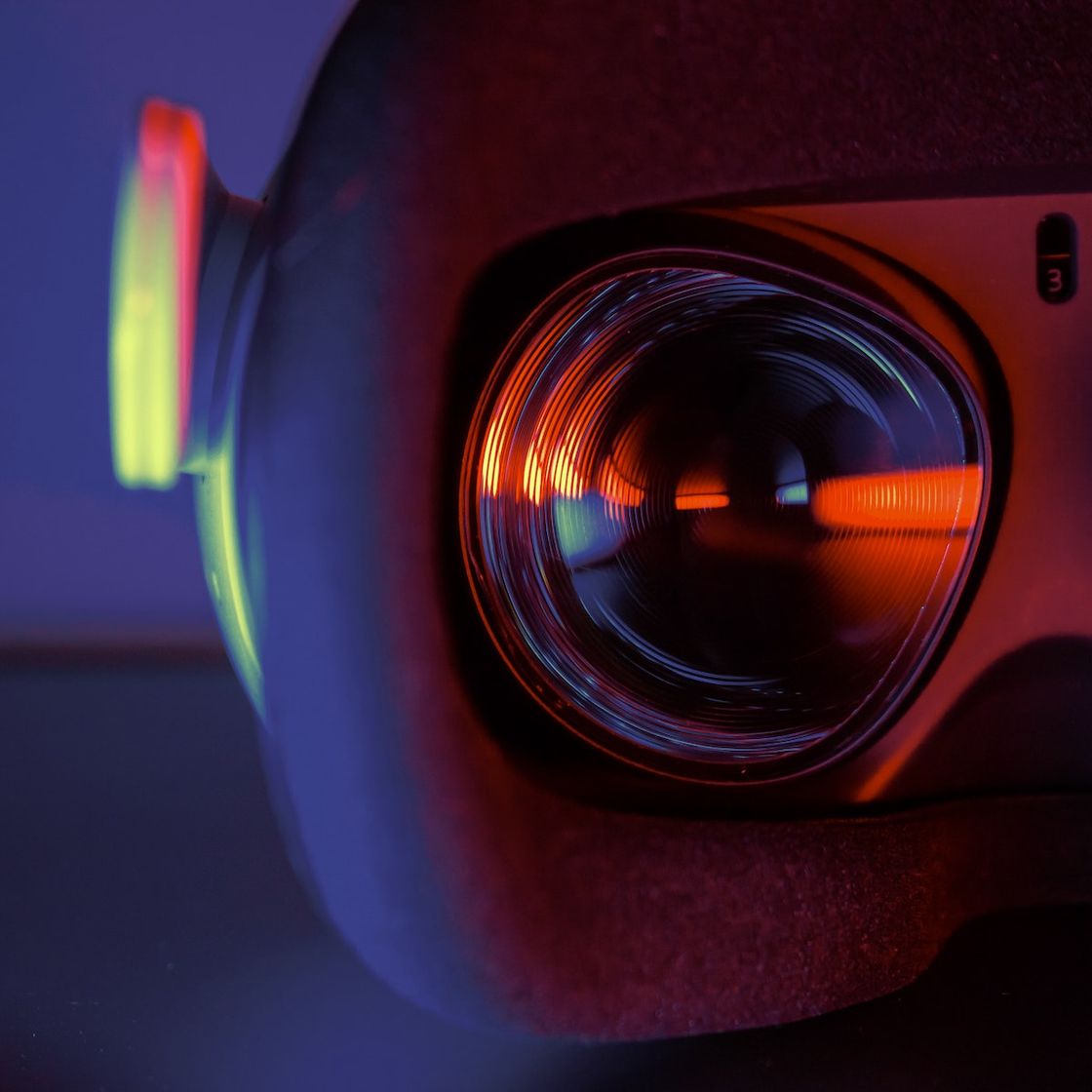 A close up of a VR headset with a glowing blue orange light